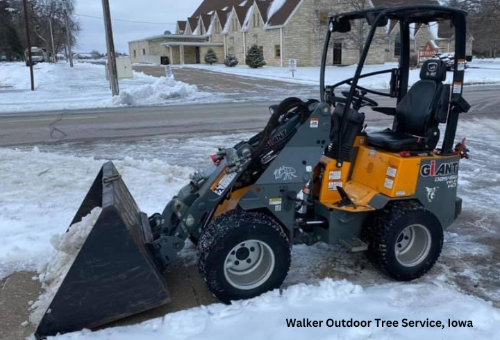 GiANT G1200 TELE with a bucket removes snow from a sidewalk in front of a church in Iowa.